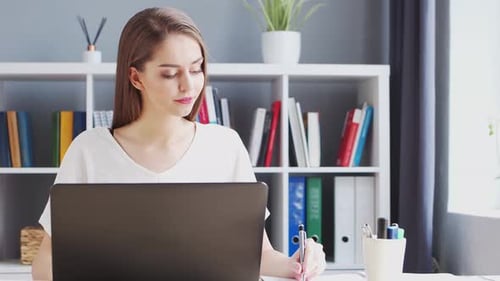 Junge Frau arbeitet im Home Office mit Computer.