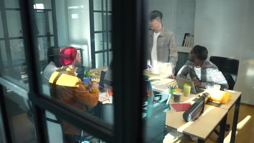 Creative Team Seen Through Glass Partition at Work