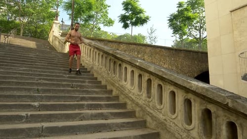 A man running on stairs in a city as a workout.