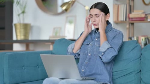 Woman Working On Laptop at Home Massages Temples