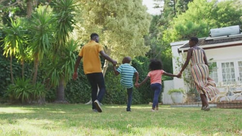 Family Running Together in Sunny Backyard