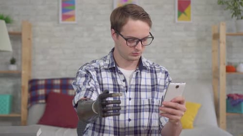 Young Adult with Prosthetic Arm Using a Phone