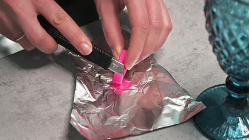 Hand made candles production, woman preparing a pink dye for wax