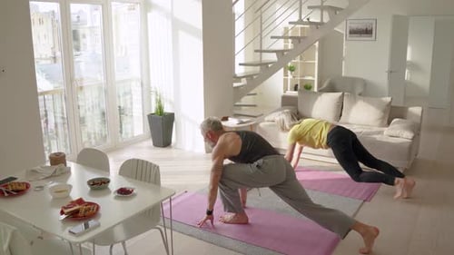 Couple Practicing Yoga Together in Bright Home