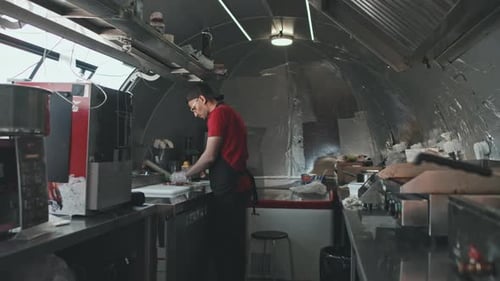 Hombre cocinando comida callejera en camión