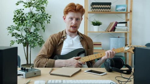 Red Haired Man Plays Electric Guitar Indoors