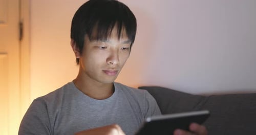Man use of tablet computer at night