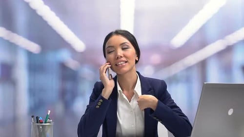 Young Woman Talking on Phone in Office