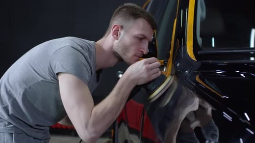 Man Buffing Car Paint with Electric Polisher