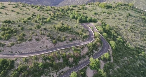 Aerial Top Down View of Cars Driving on a Curvy Road on the Mountain