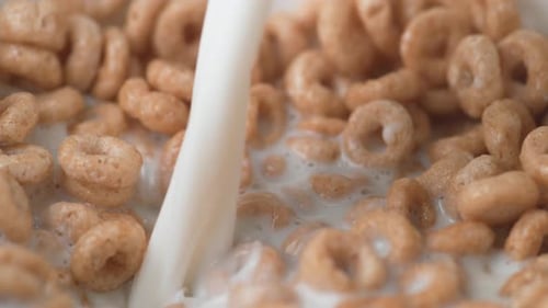 Milk Being Poured Over Round Cereal in Bowl