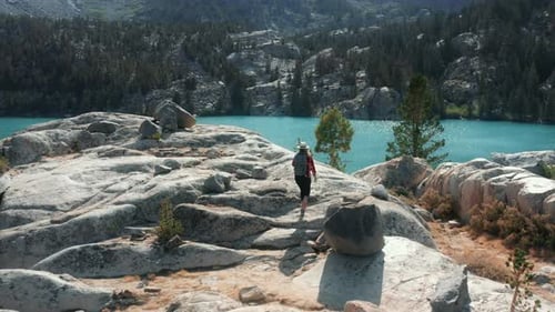 Camera Following Woman Walking By the Rocky Mountain To the Beautiful Blue Lake