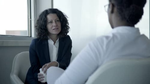 Lächelnde Geschäftsfrauen sprechen im Büro