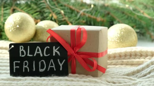 Gift Box and Promotional Sign of Black Friday on the Christmas Background