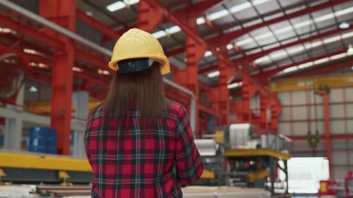 Back professional heavy Industry engineer woman worker wearing safety helmet using clipboard
