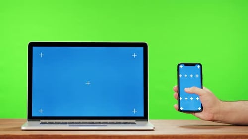 Laptop and Smartphone with Blue Chroma Key on Green Background Closeup