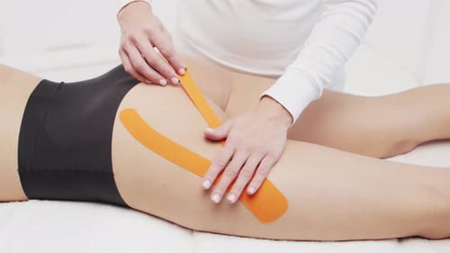 Woman Receiving Therapeutic Kinesiology Taping Treatment