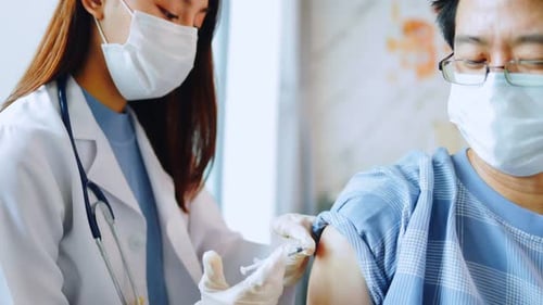 Medical Professional Giving Injection to Patient in Clinic