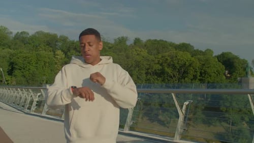 Young Adult Runs on Pedestrian Bridge