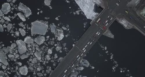 Deriva de hielo en río y puente cruzándolo