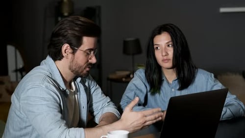 Portrait d'un jeune couple assis devant un carnet à la maison