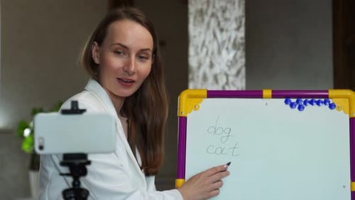 Female Teacher Explains Lesson at Whiteboard
