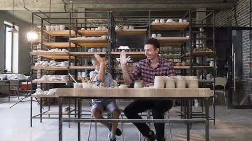 Young Boy and Man Creating Pottery in Bright Studio