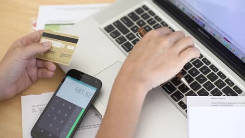 Woman calculating bills on smart phone
