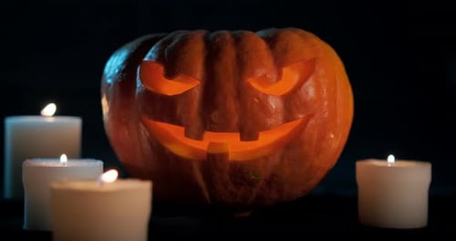 Spooky Jack-o'-lantern Surrounded by Candles on Dark Background