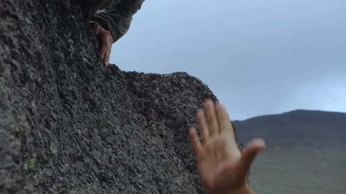 Helping Hand on Rock Face in Mountain