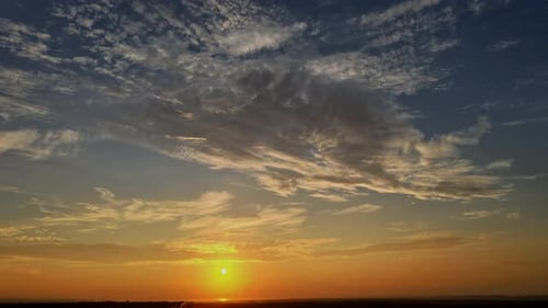 Dramatisch sanfter Sonnenaufgang, wunderschöne rosa-violette, orange Wolken vor blauem Himmel