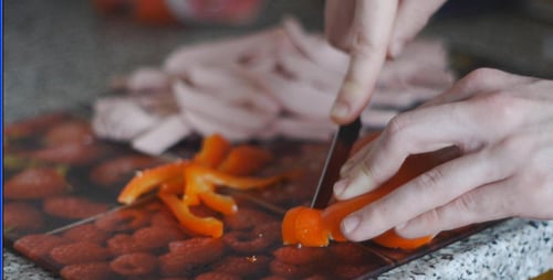Un cuisinier coupe le poivre