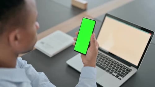 African Man Using Smartphone with Green Chroma Key Screen
