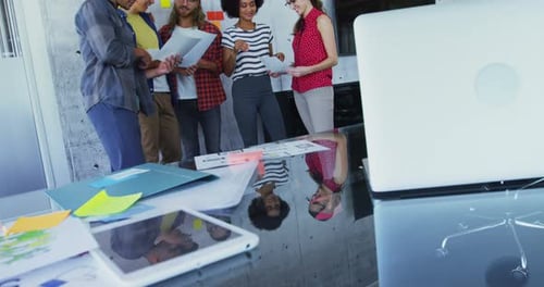 Team Discussing Ideas Around Meeting Table in Modern Office