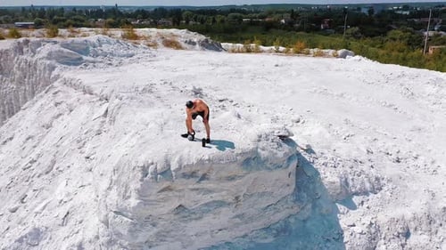 Brutal strong bodybuilder pumping up muscles. Bodybuilding and outdoor sports concept. Aerial view.