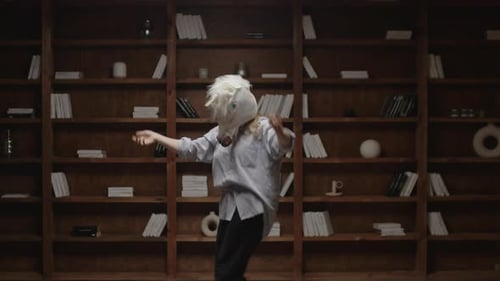 Person in Unicorn Head Mask Dancing in Library at Home