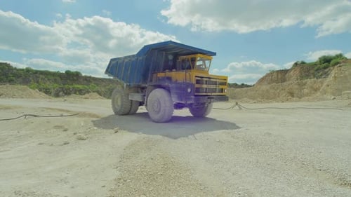 Industrial Dump Truck Raising Truck Bed on a Bright Day