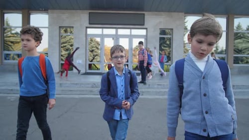 Niños alegres de primaria que salen de la escuela