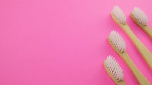 Wooden Toothbrushes on Bright Pink Background