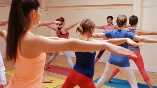 Yoga Class with Adults Exercising in Studio