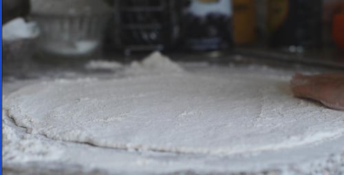 Person Rolling Out Dough With a Rolling Pin