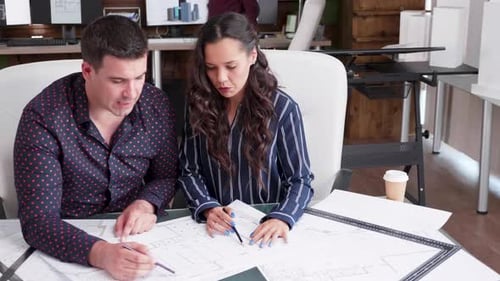 Contructor Engineer and Female Architect Working in a Office with Blueprints
