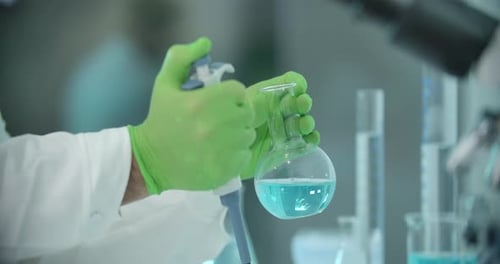 Person Mixing Chemicals in Lab with Pipette