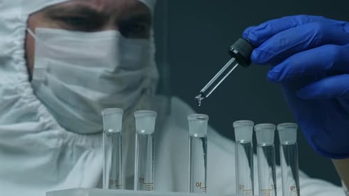 Scientist or Doctor Dispenses Reagent Into a Glass Tube. Laboratory Glassware Containing Chemical