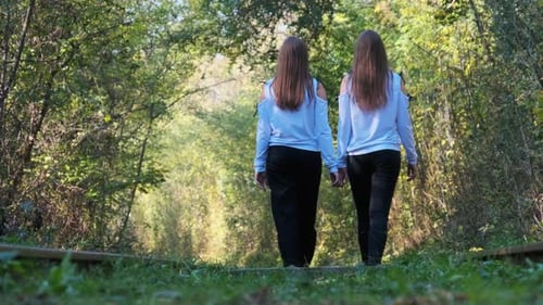 Two Young Women Walk Together in Forest