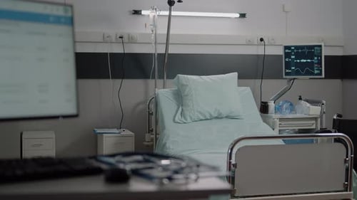 Empty Bed in Hospital Ward with Medical Equipment
