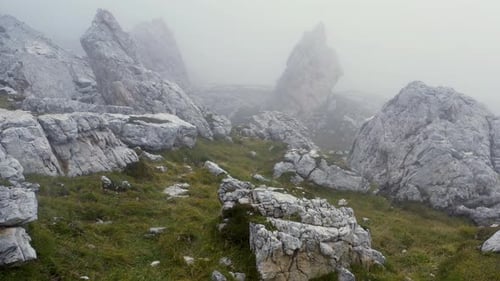 Misty Mountain Landscape with Jagged Rocks and Greenery