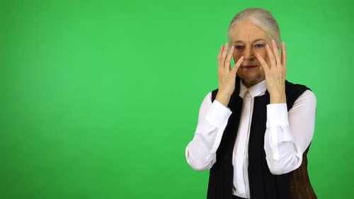 An Elderly Woman Uncovers Her Eyes and Looks Around in Confusion