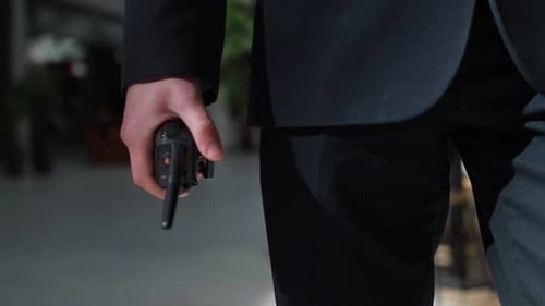 Le gardien tient un talkie-walkie à la main. Main d'un agent de sécurité tenant un interphone dans la sienne