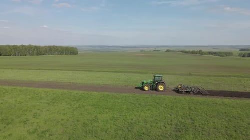 Un tracteur laboure la terre sur un champ non cultivé